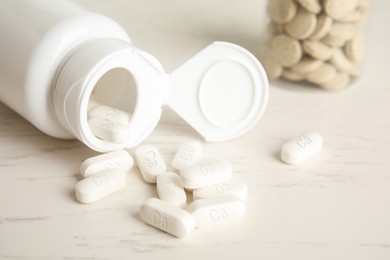 Image of Calcium supplement. Bottle with pills on light table, closeup