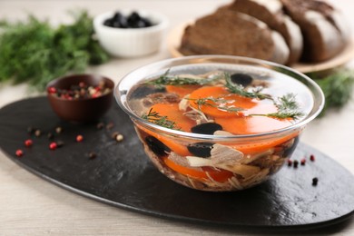 Delicious aspic with meat and vegetables served on light wooden table, closeup