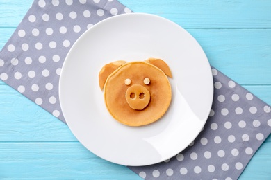 Photo of Funny pancake for kids breakfast on wooden table, top view