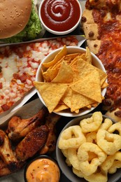 Photo of Onion rings, pizza and other fast food as background, top view