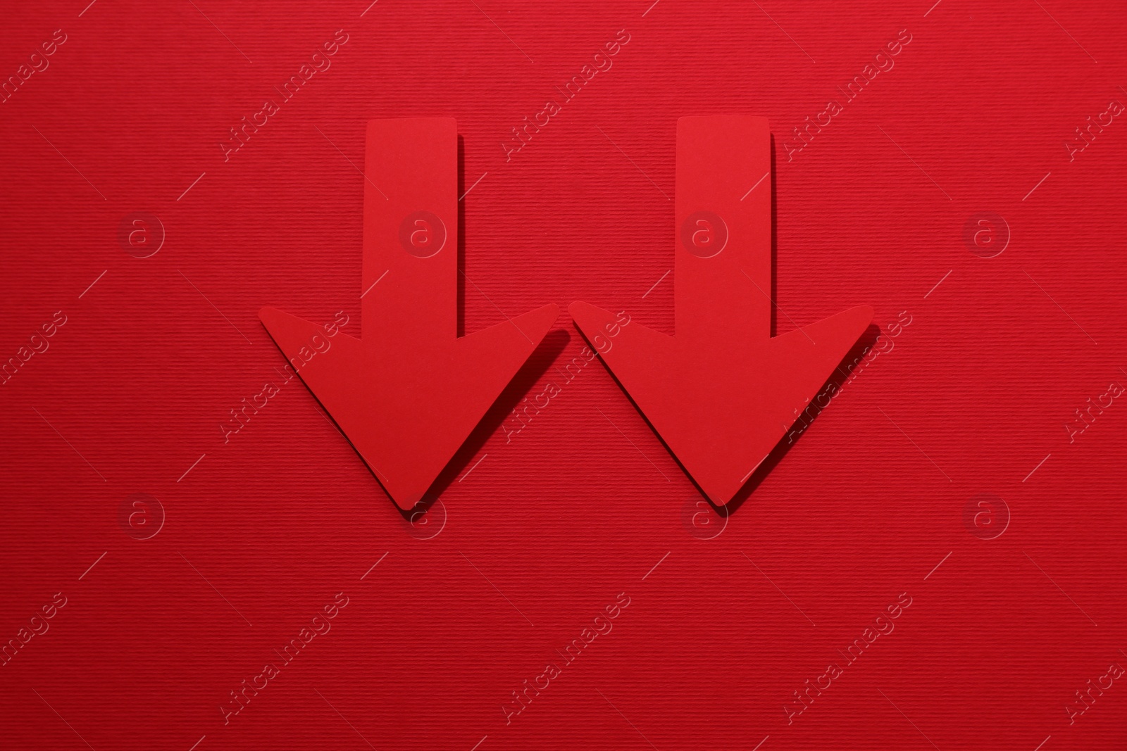 Photo of Paper arrows on red background, flat lay