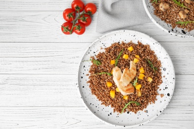 Flat lay composition with tasty buckwheat porridge on white wooden table, space for text