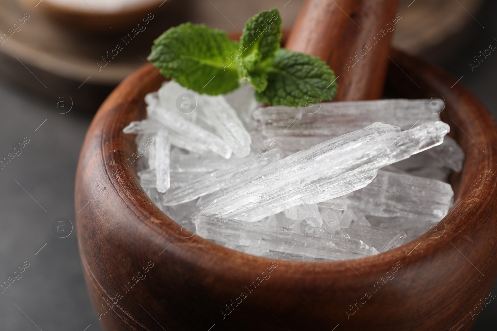 Photo of Menthol crystals and mint leaves in mortar, closeup