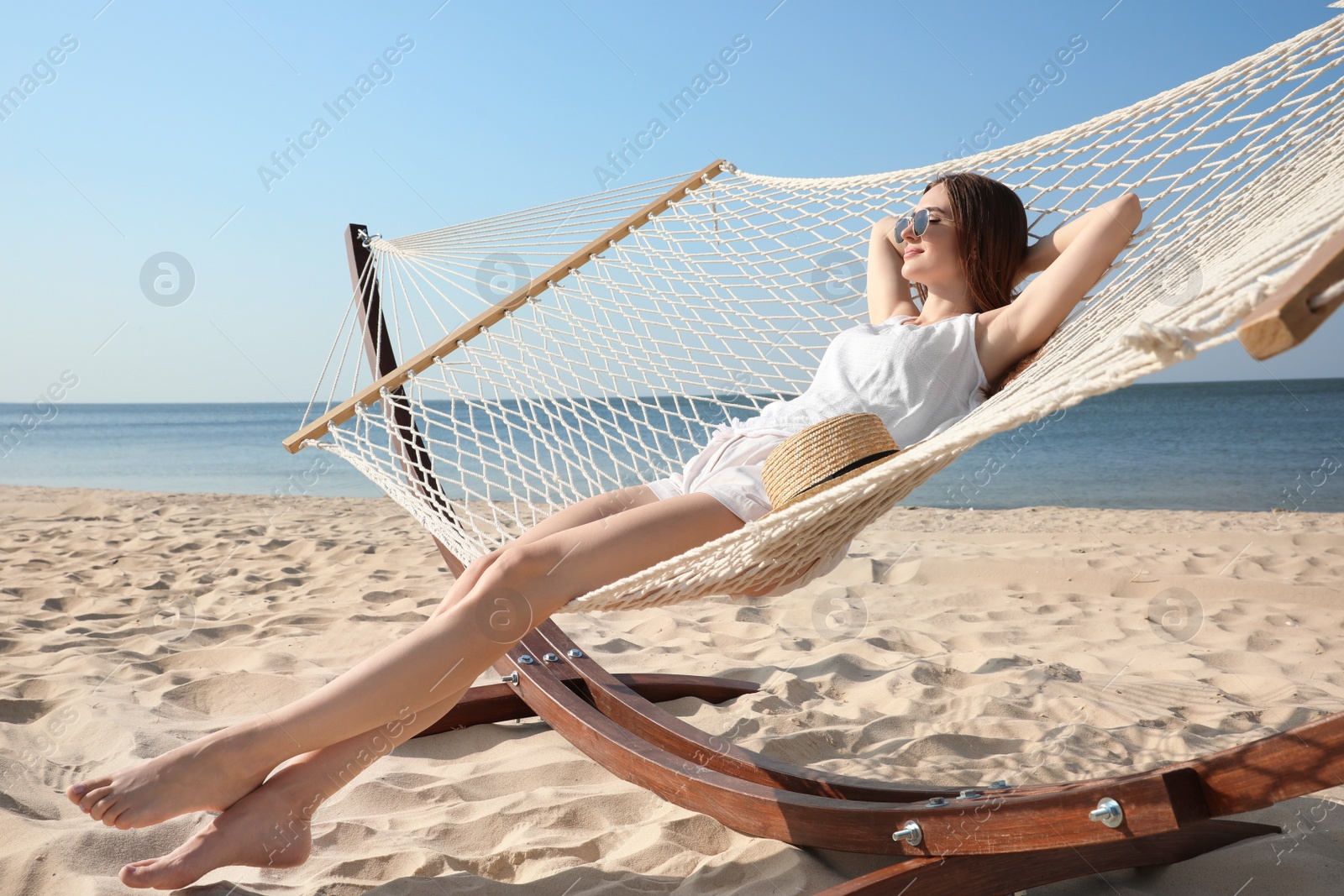 Photo of Young woman relaxing in hammock on beach