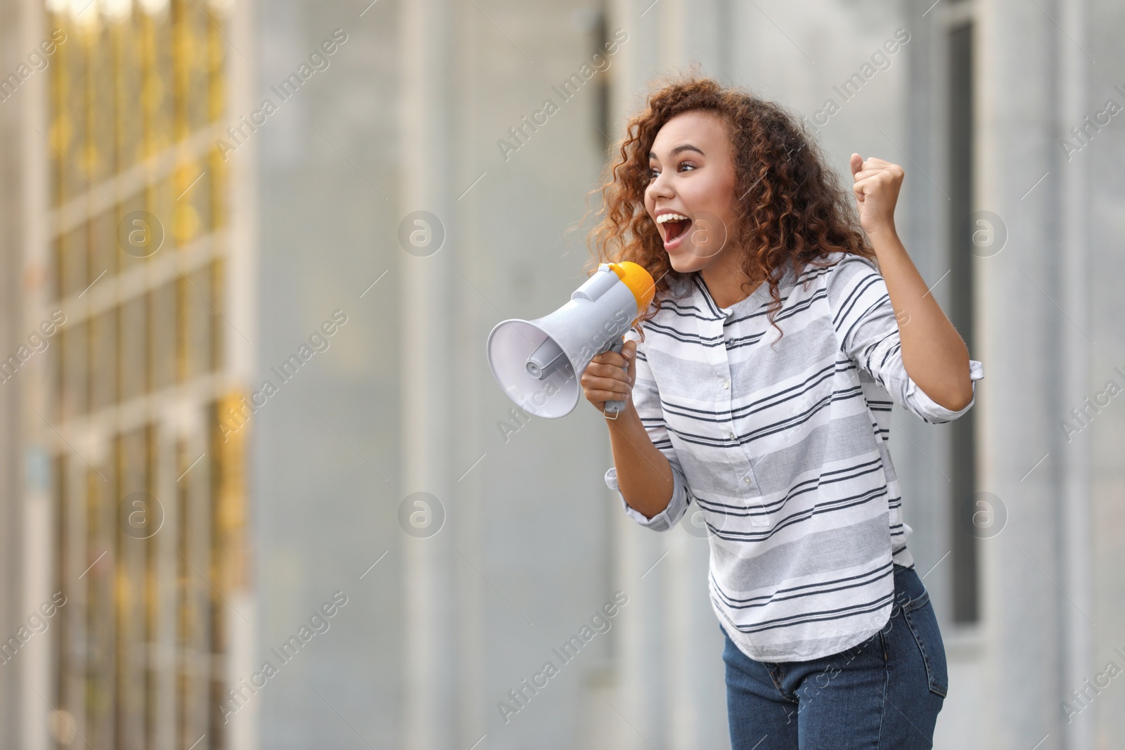 Image of Emotional African American young woman with megaphone outdoors. Protest leader