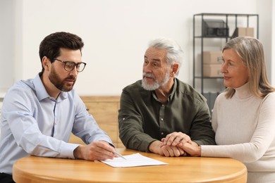 Notary consulting senior couple about Last Will and Testament in office