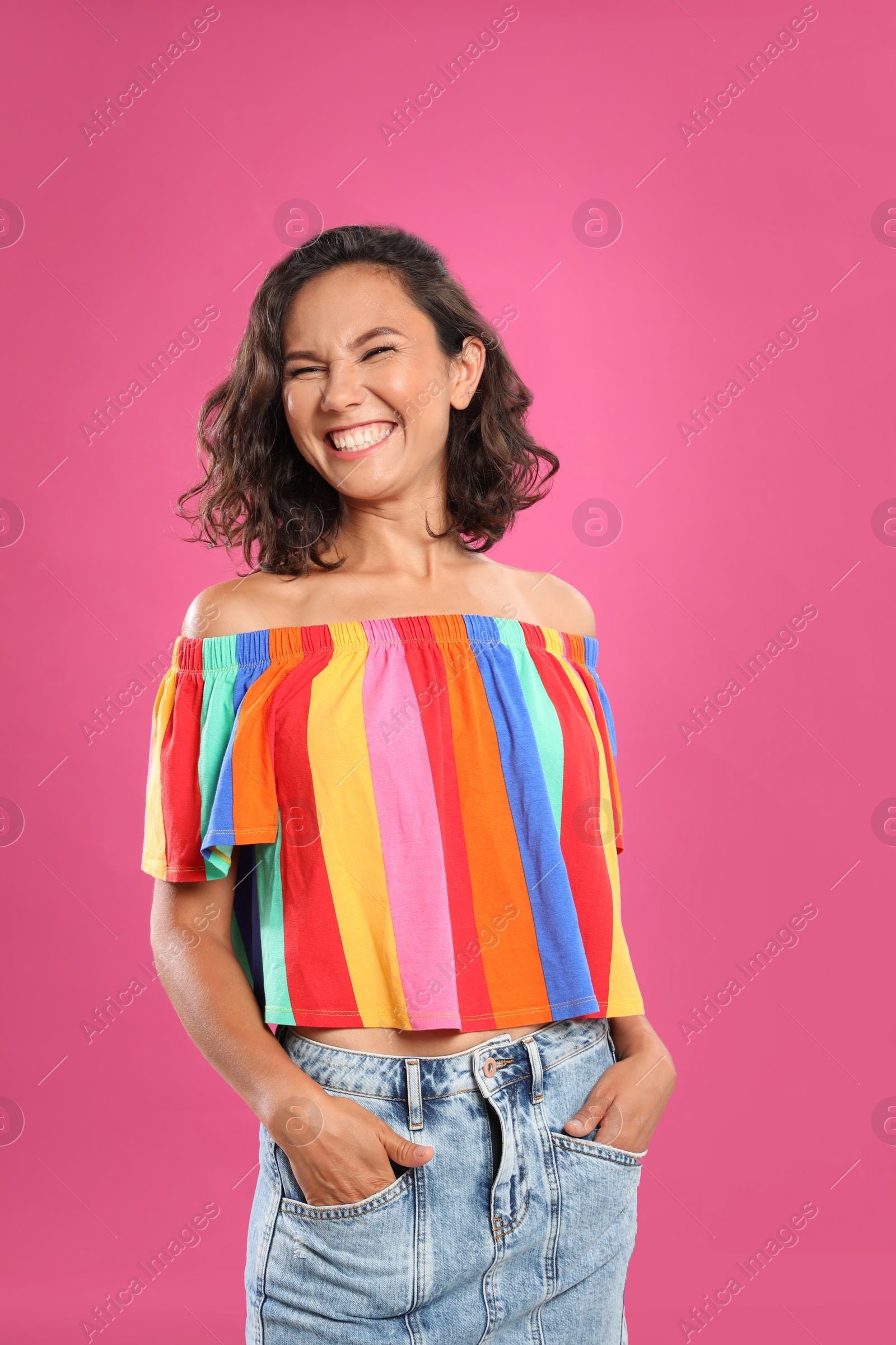 Photo of Happy young woman in casual outfit on pink background