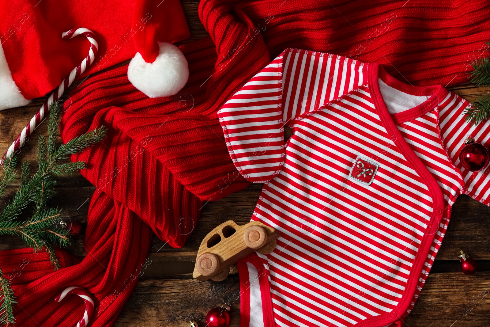 Photo of Flat lay composition with Christmas baby clothes on wooden background