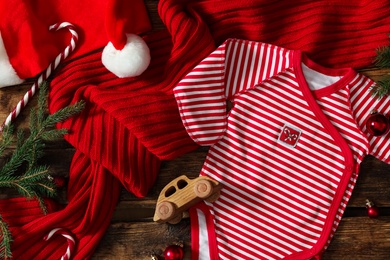 Photo of Flat lay composition with Christmas baby clothes on wooden background