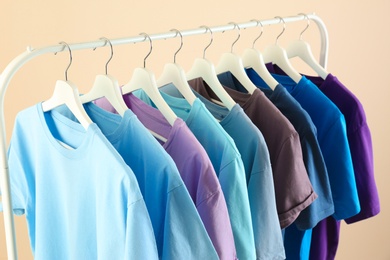 Men's clothes hanging on wardrobe rack against light background