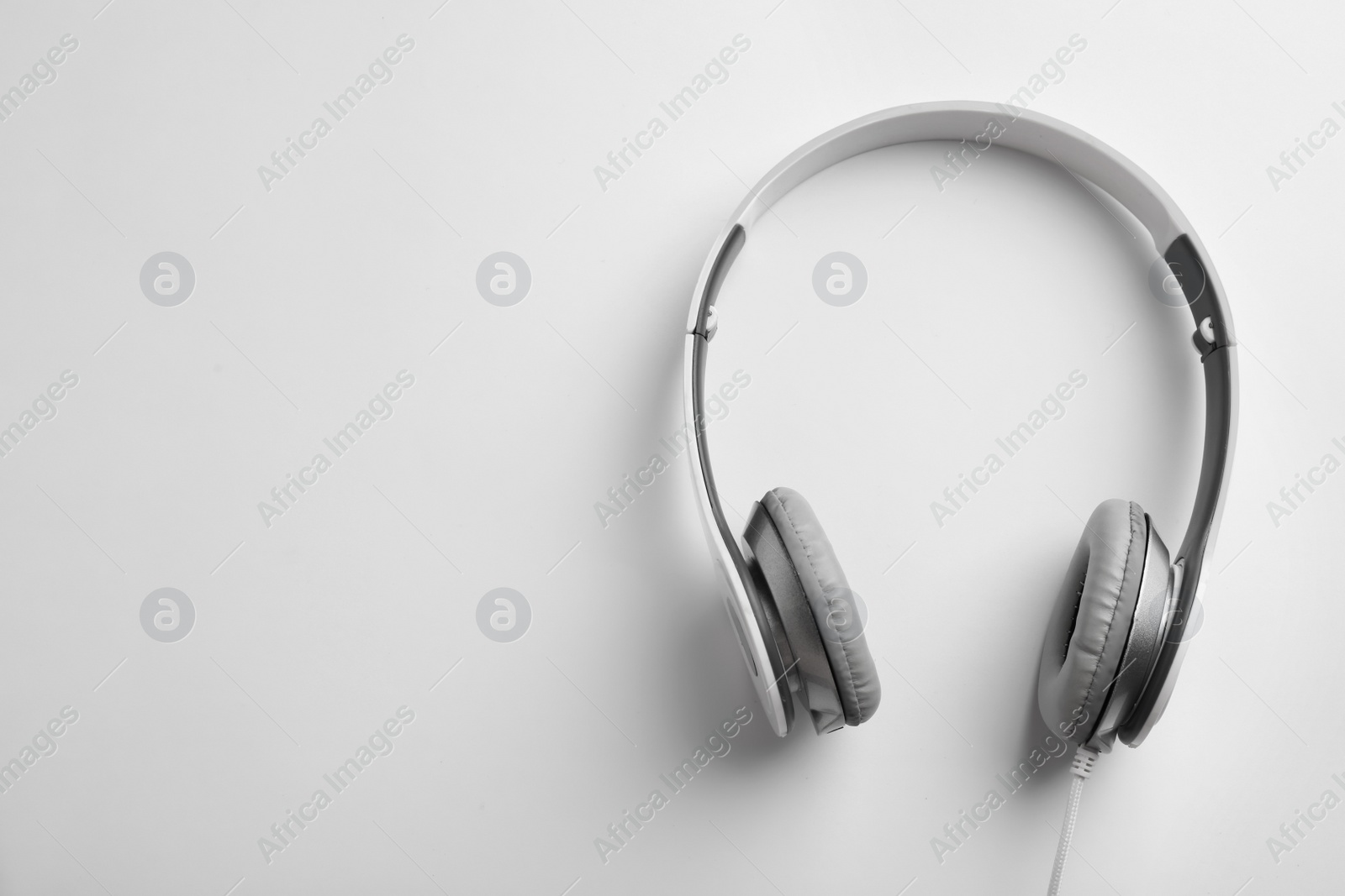 Photo of Stylish modern headphones with earmuffs on white background, top view. Space for text