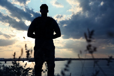 Photo of Soldier in uniform patrolling outdoors. Military service