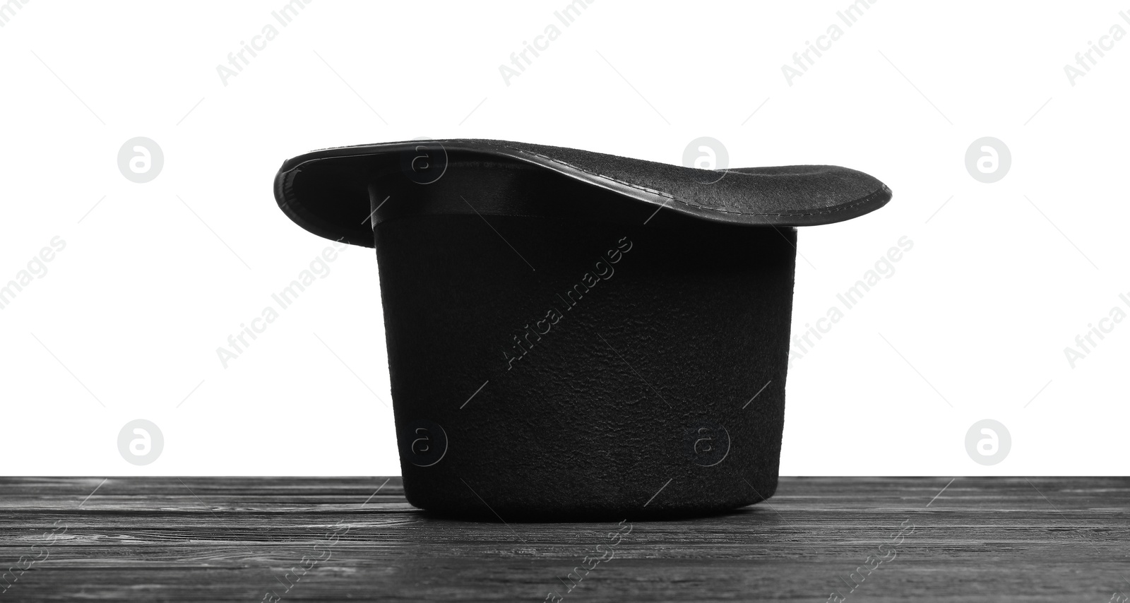 Photo of Magician's hat on wooden table against white background