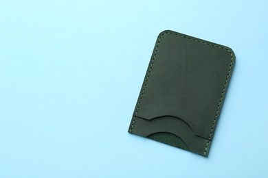 Empty leather card holder on light blue background, top view. Space for text