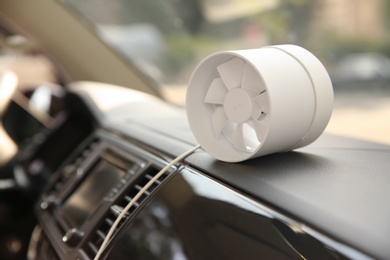 Photo of Portable fan on dashboard in car. Summer heat