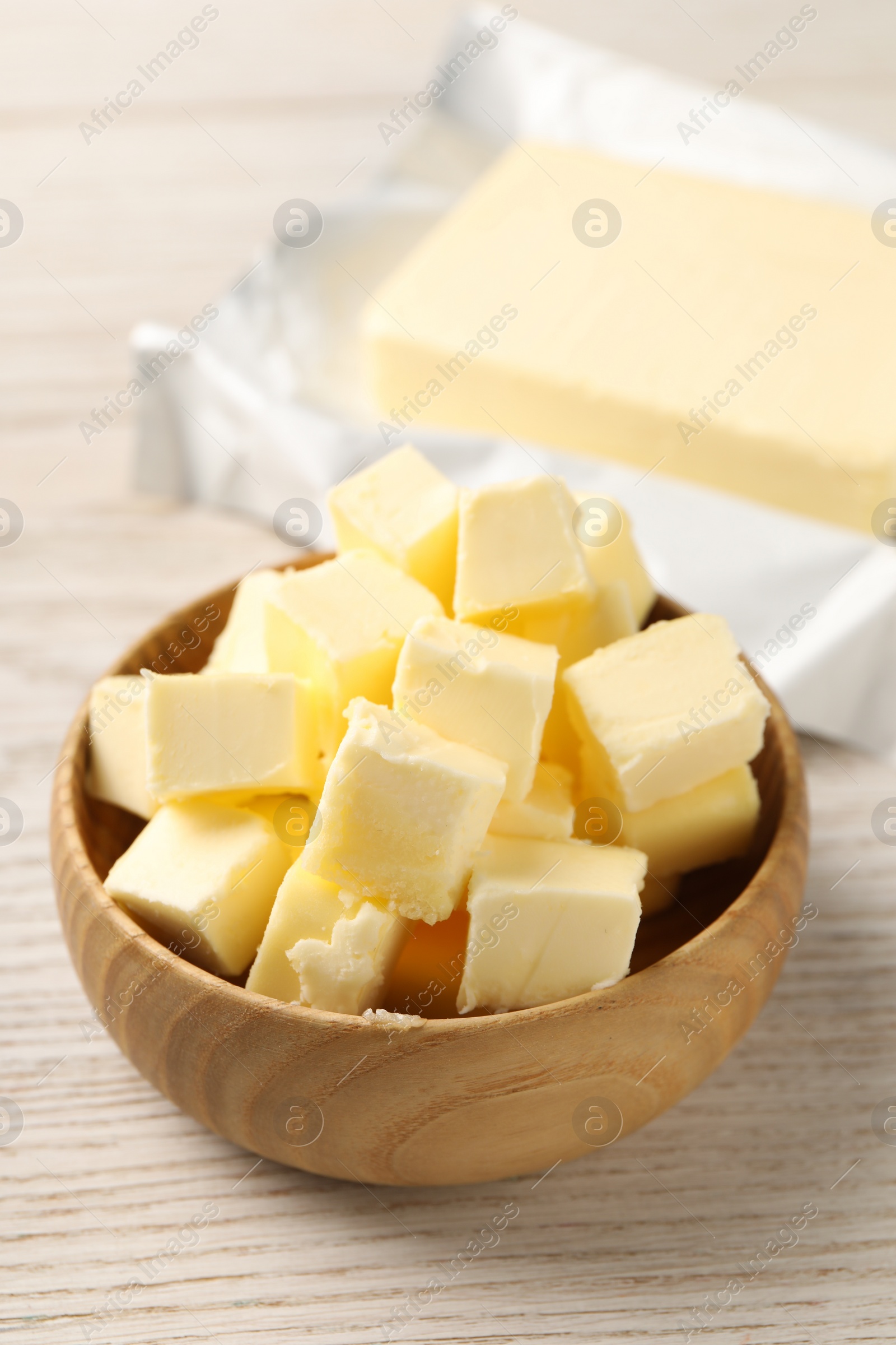 Photo of Tasty butter on light wooden table, closeup