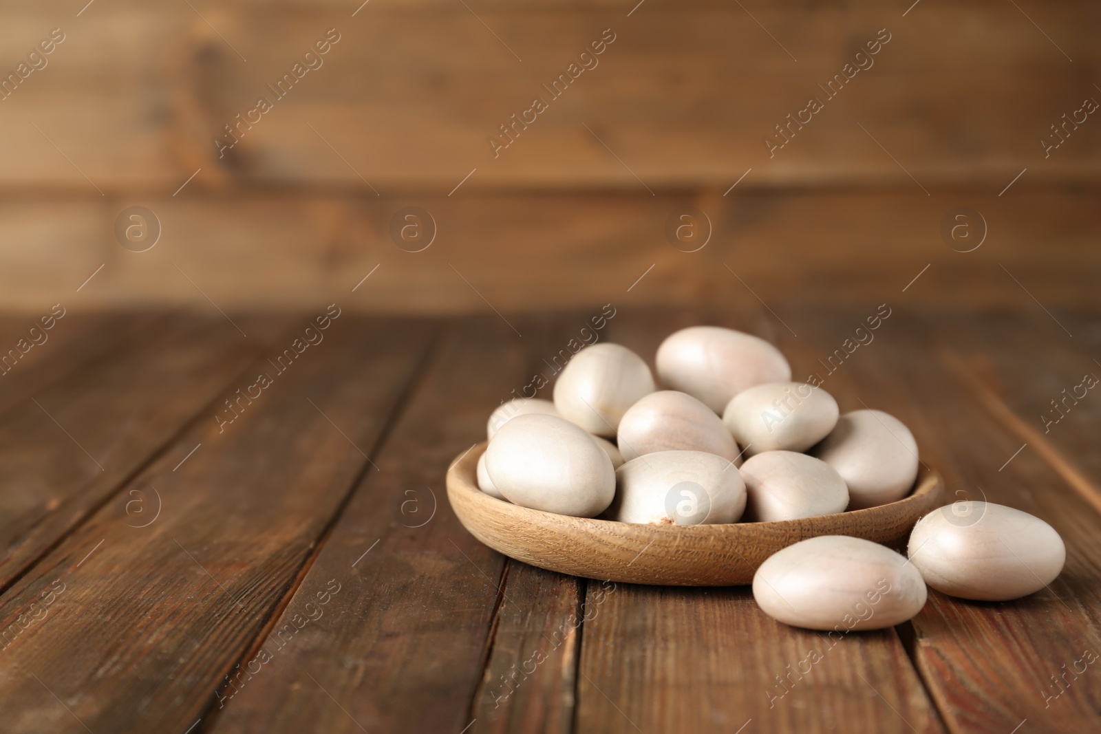 Photo of Raw jackfruit seeds on wooden table. Space for text