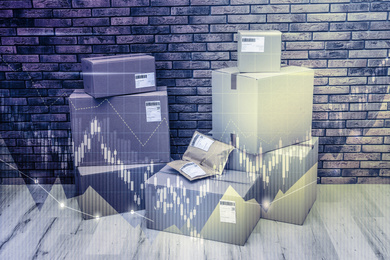 Image of Wholesale trading. Stack of cardboard boxes on floor against brick wall, black and white effect