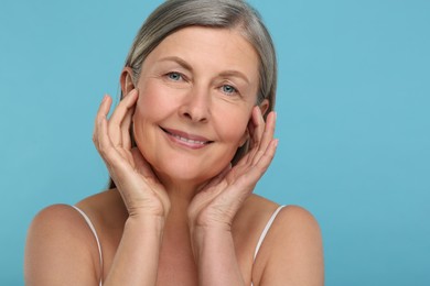 Photo of Portrait of senior woman with aging skin on light blue background. Rejuvenation treatment