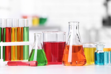 Photo of Different glassware with samples on table in chemistry laboratory