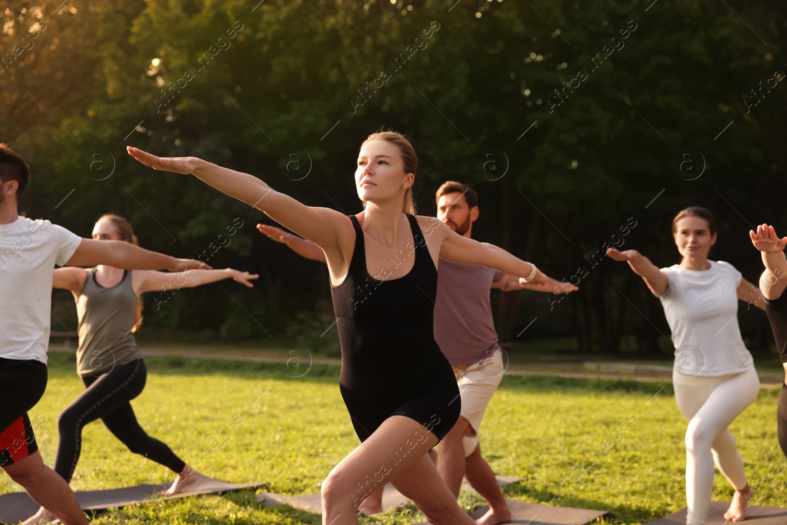 Photo of Group of people practicing yoga on mats outdoors