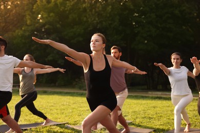 Photo of Group of people practicing yoga on mats outdoors