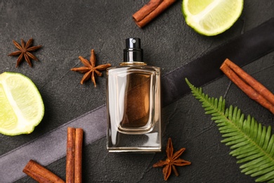 Photo of Beautiful composition with bottle of perfume on dark background, flat lay