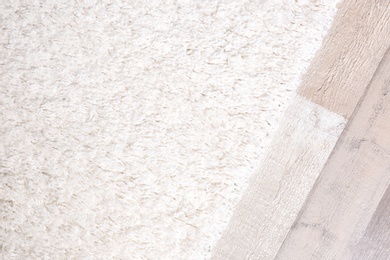 Photo of Light soft carpet on wooden floor