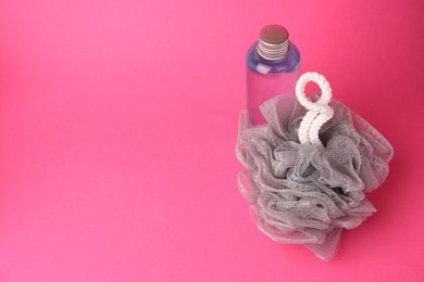 Photo of Grey shower puff and bottle of cosmetic product on pink background, space for text