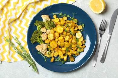 Photo of Tasty baked yellow carrot with broccoli, cauliflowers and pea sprouts served on light grey marble table, flat lay