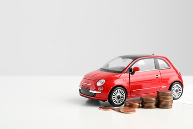Photo of Toy car and money on white background, space for text. Vehicle insurance