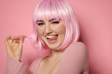 Photo of Happy woman with bright makeup and fake freckles on pink background