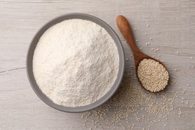 Ceramic bowl with quinoa flour and seeds on wooden table, flat lay