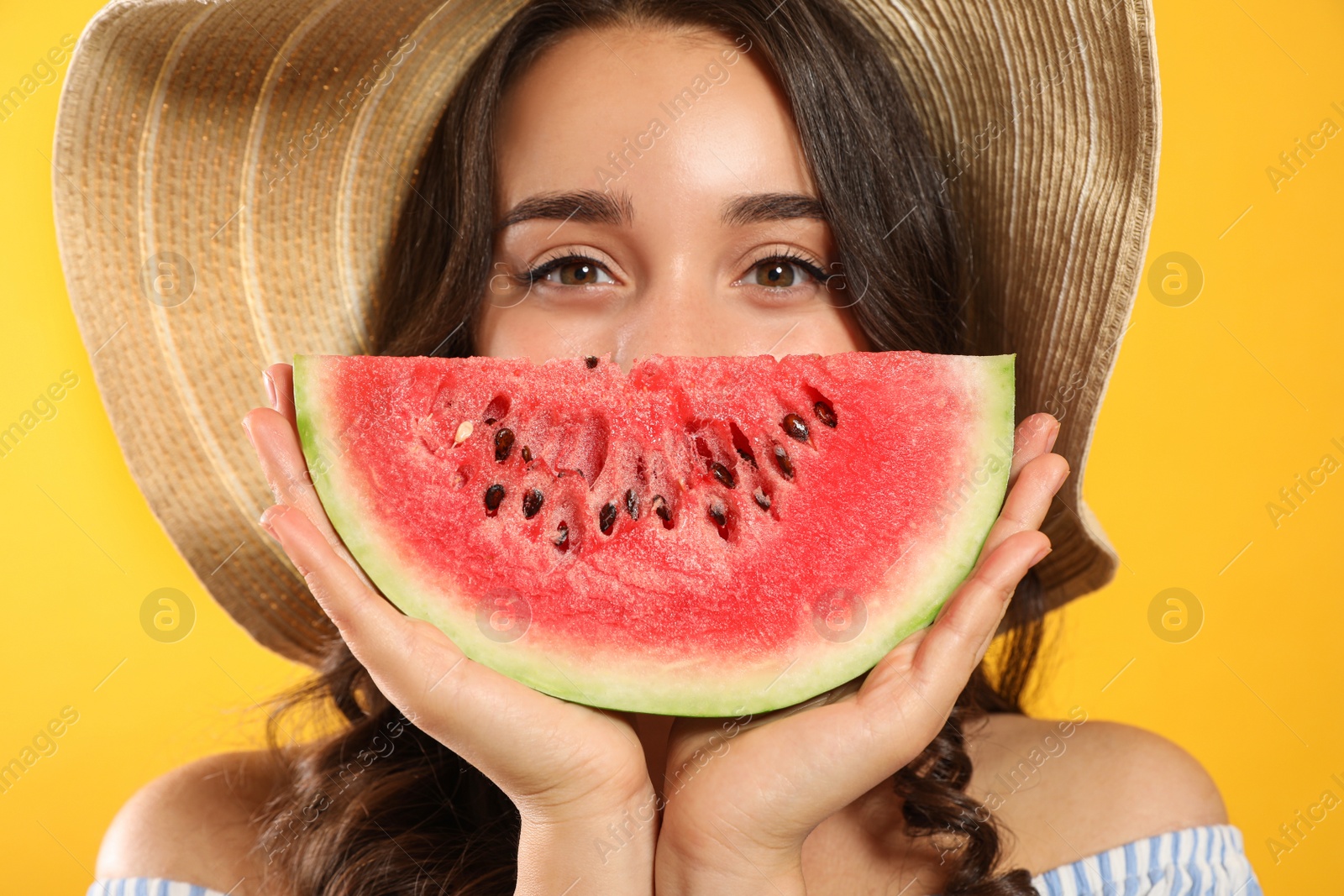 Photo of Beautiful young woman with watermelon on yellow background, closeup