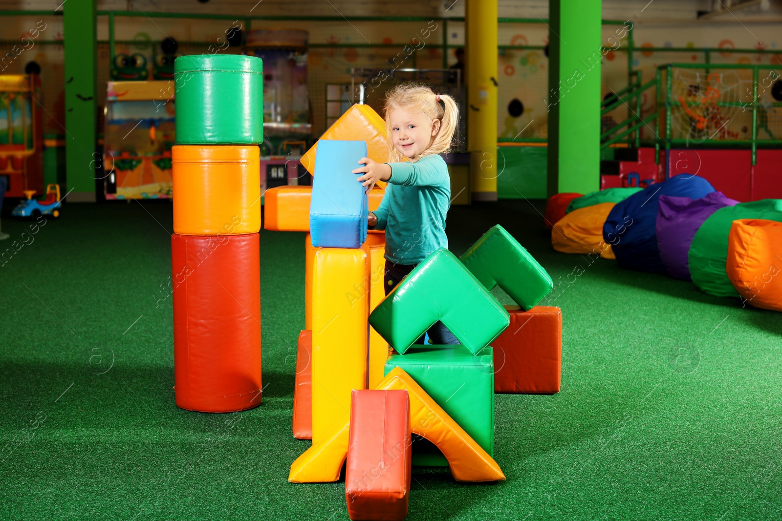 Photo of Cute child playing with colorful building blocks indoors