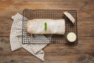 Delicious strudel with tasty filling served on wooden table, top view