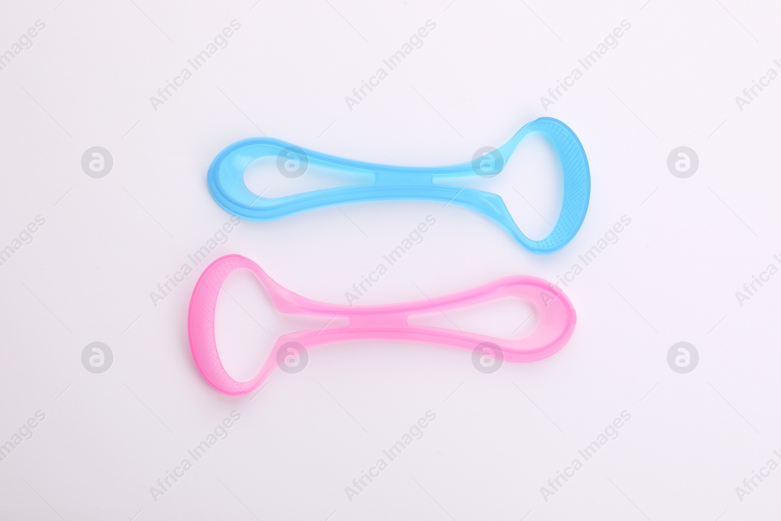 Photo of New colorful tongue cleaners on white background, top view