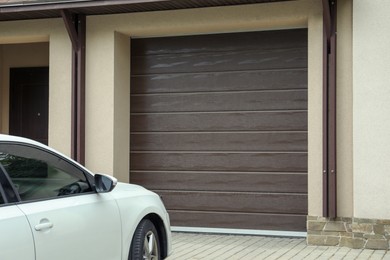 Photo of Building with brown sectional garage door and parked car