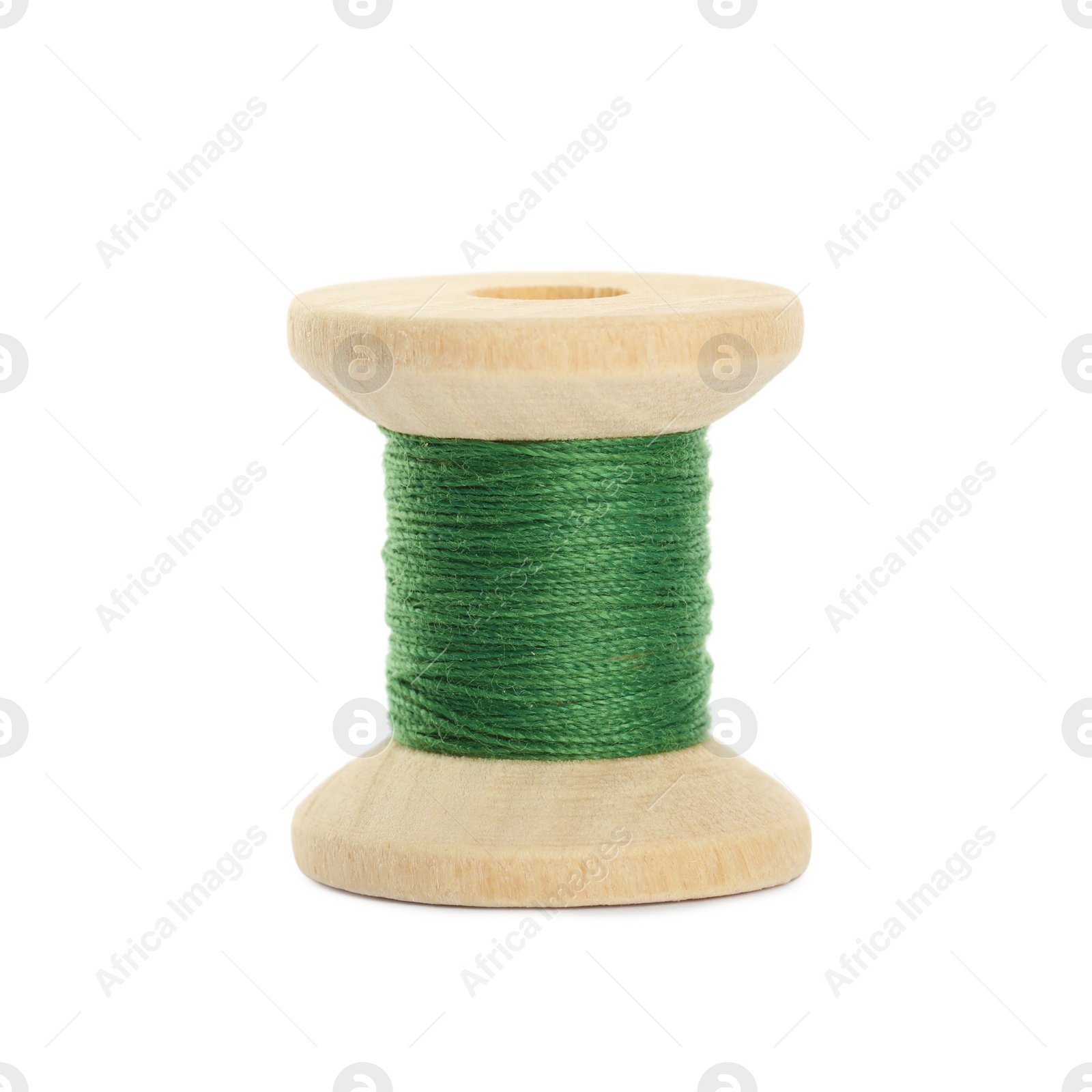 Photo of Wooden spool of green sewing thread isolated on white