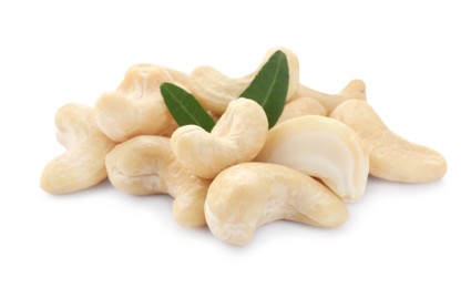 Photo of Pile of tasty organic cashew nuts and green leaves isolated on white