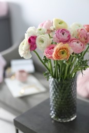 Photo of Bouquet of beautiful ranunculuses on table in living room