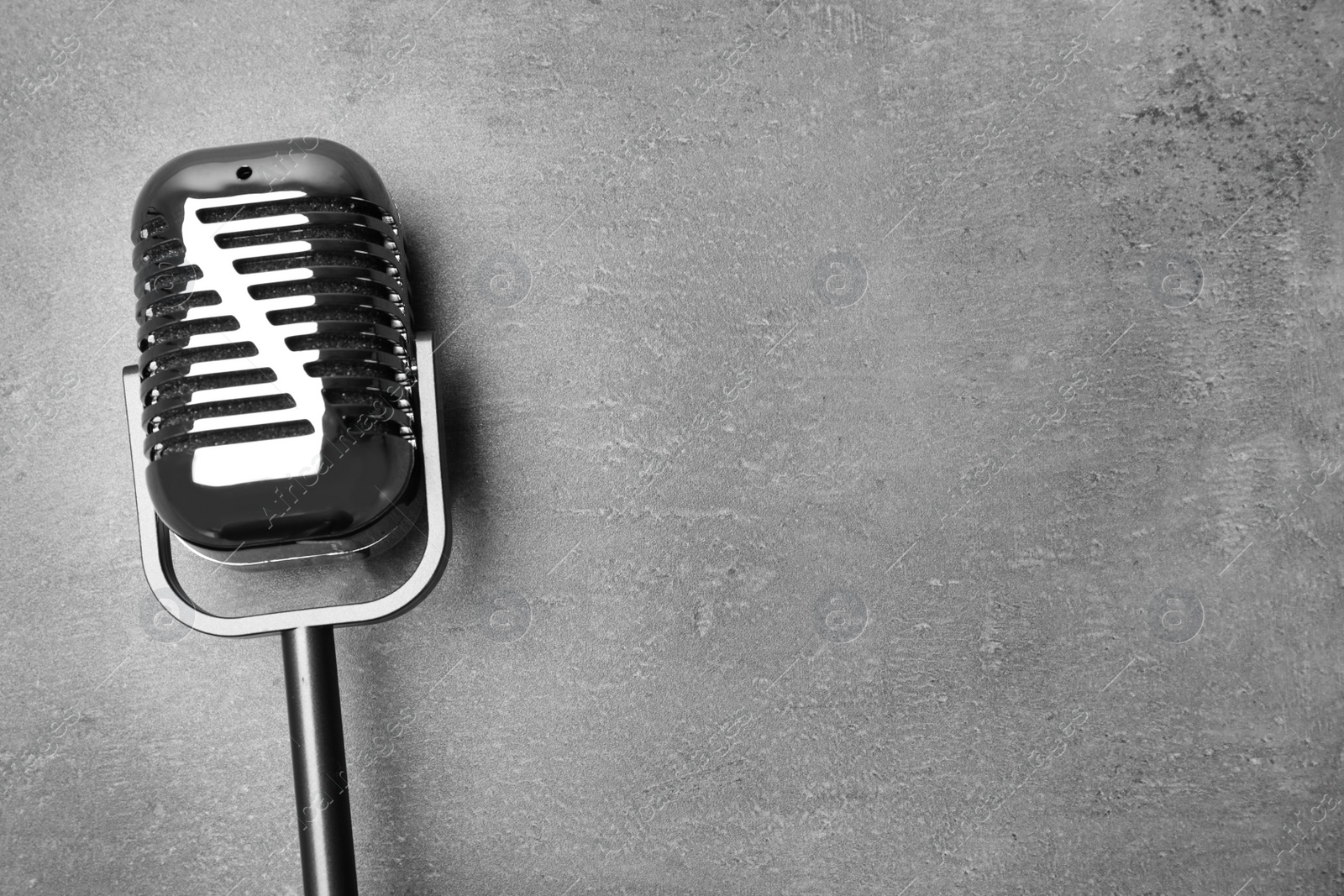 Photo of Retro microphone on grey background, top view with space for text