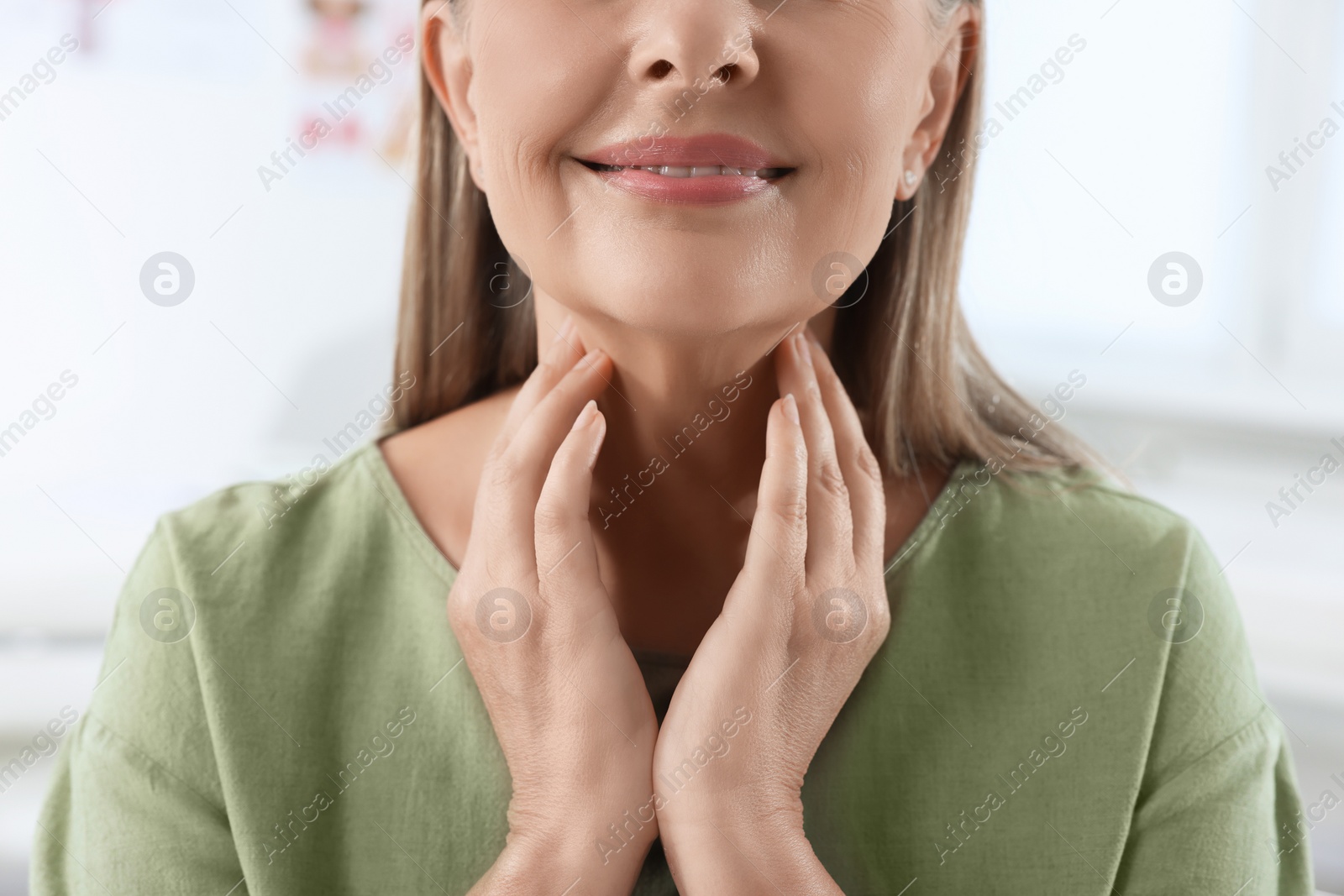 Photo of Endocrine system. Senior woman doing thyroid self examination indoors, closeup