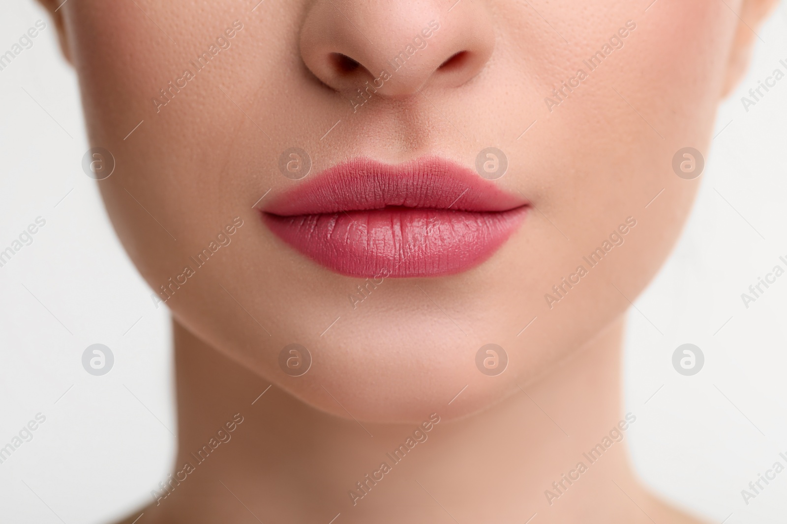 Photo of Young woman with beautiful full lips on white background, closeup