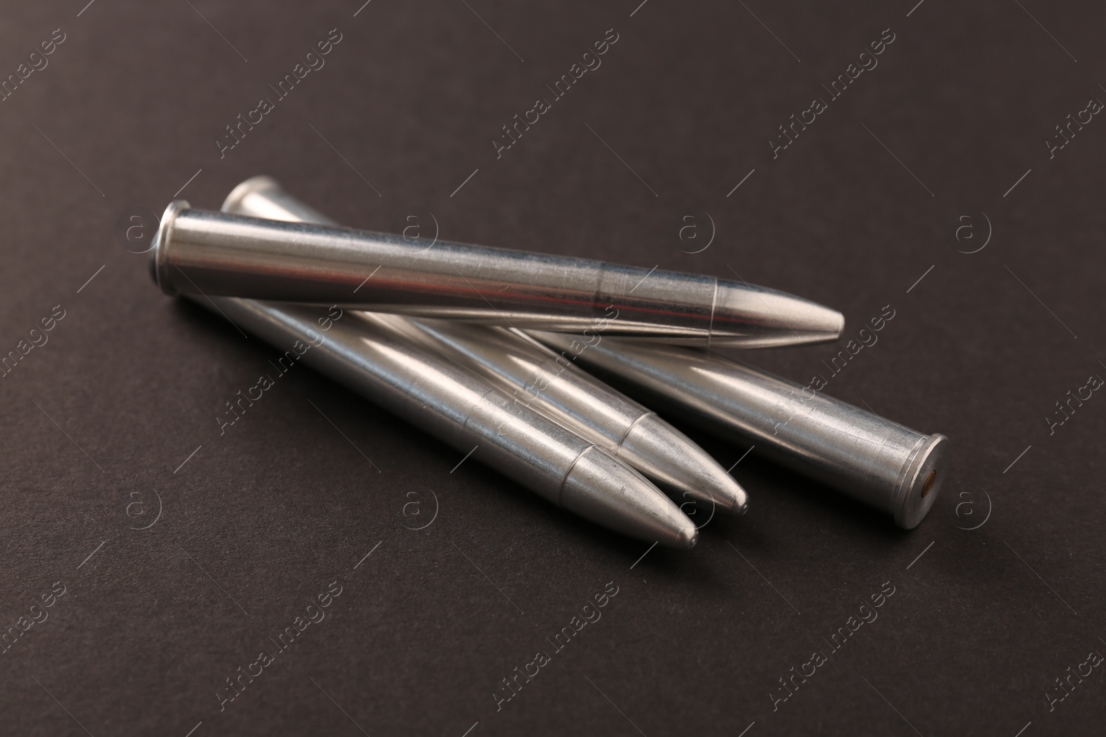 Photo of Many metal bullets on black background, closeup