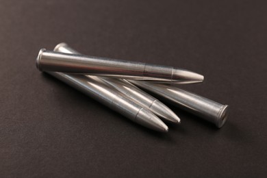 Photo of Many metal bullets on black background, closeup
