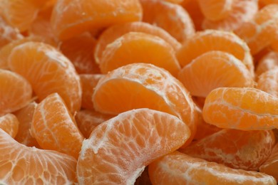 Photo of Delicious tangerine segments as background, closeup view