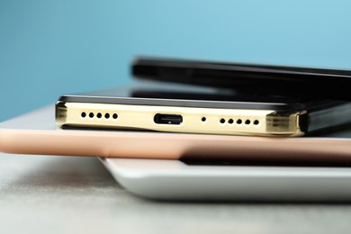 Stack of electronic devices on grey table, closeup