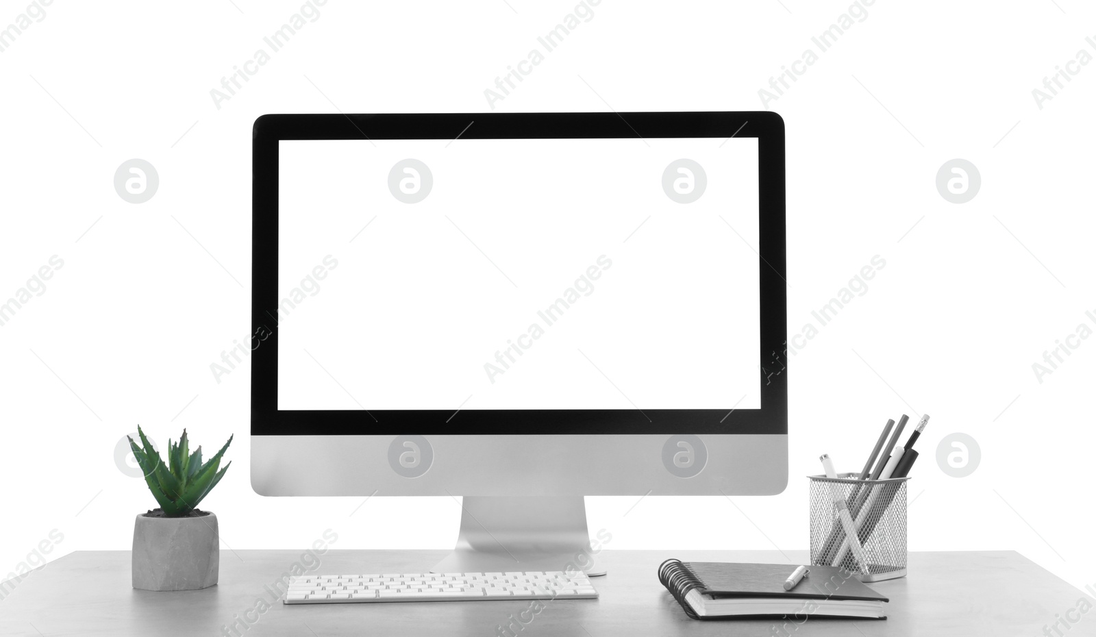 Photo of Computer, potted plant and stationery on table against white background. Stylish workplace