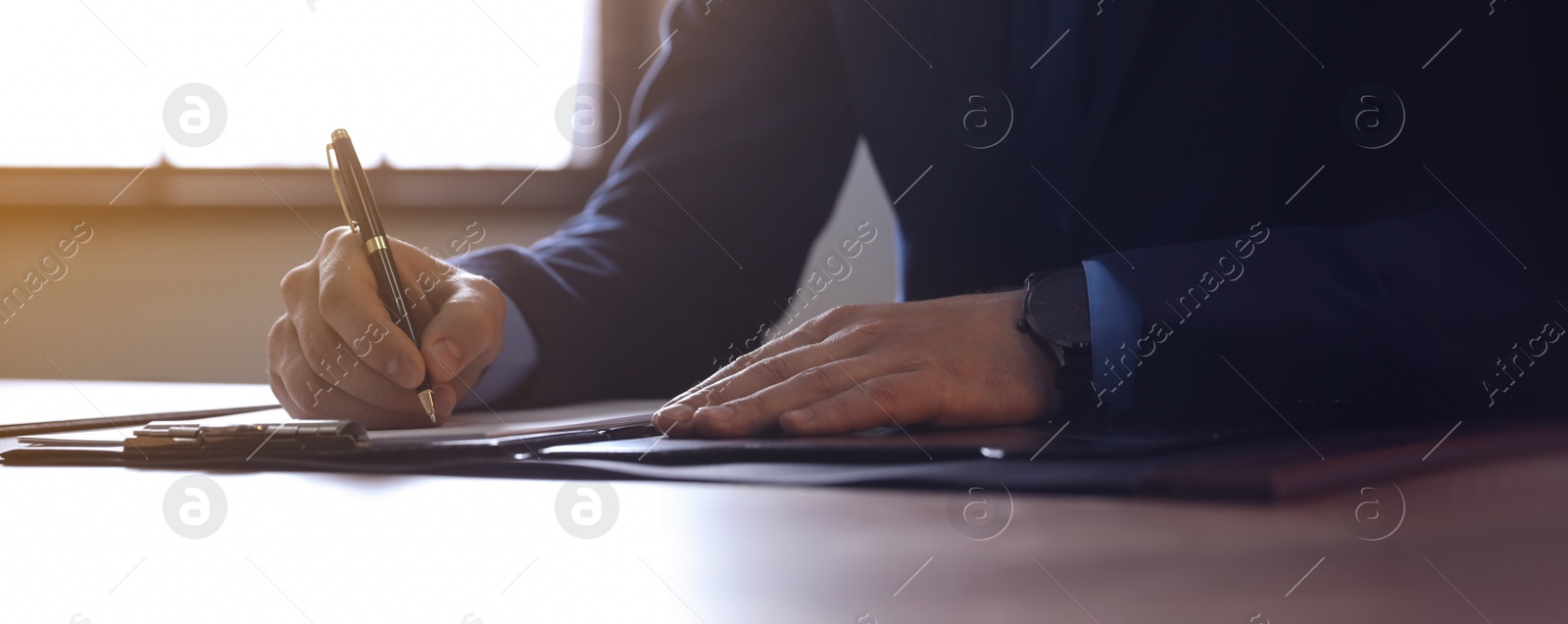 Image of Male lawyer working at table in office, closeup. Banner design